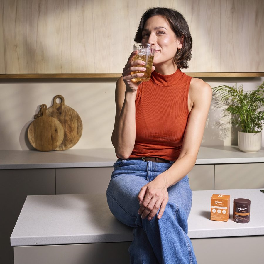 Donna che beve il suo bicchiere di Energy la mattina in cucina