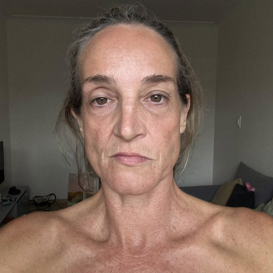 Selfie de Sophie, milieu de la cinquantaine, peau fatiguée et terne avec des rides profondes, regardant la caméra avec déception