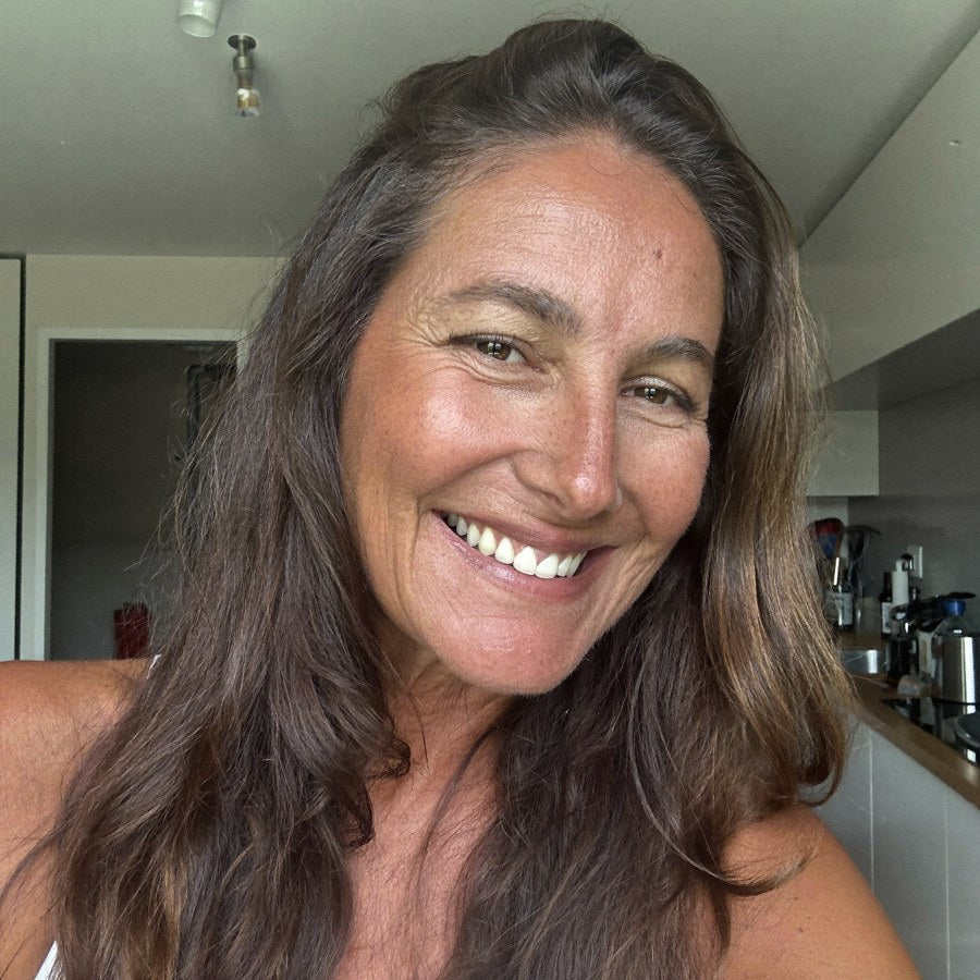 Selfie di Chiara, poco più di 50 anni, pelle radiosa e piena e capelli folti, sorride nella sua cucina