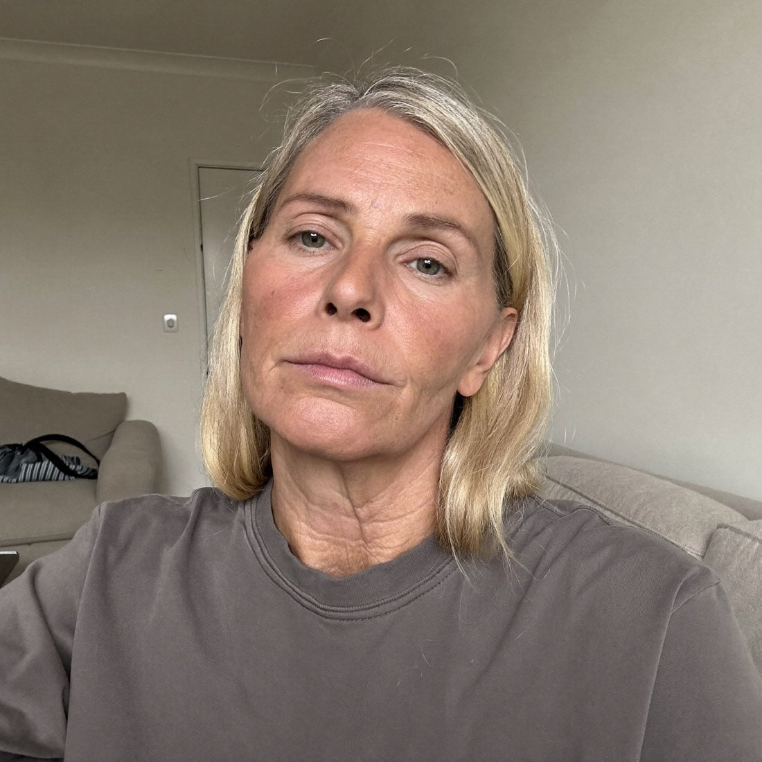 Selfie van Petra, midden 50, vermoeide, fletse huid met diepe rimpels, kijkt teleurgesteld in de camera